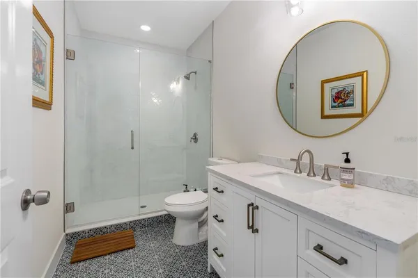 a bathroom with a granite countertop sink mirror and toilet