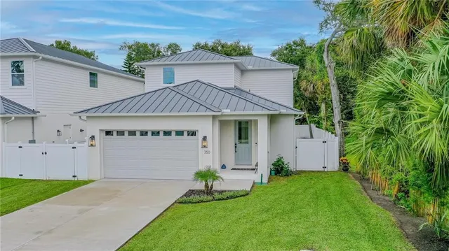 a front view of a house with a garden and plants