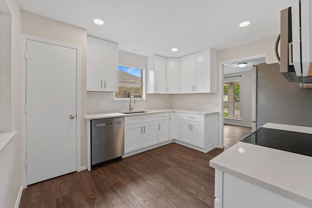 4007 Ridgebrook Drive Arlington, TX 76015 - Photo 8 of 18 Kitchen featuring white shaker cabinetry, light-toned countertops, stainless steel appliances, dark wood-finish flooring, and recessed lighting