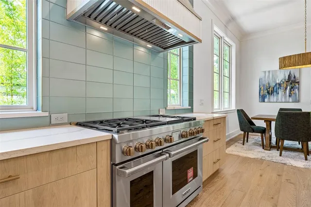 a large kitchen with kitchen island a large counter space a sink appliances and a large window