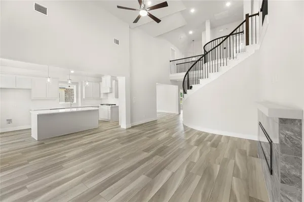 a view of a kitchen with wooden floor and a ceiling fan