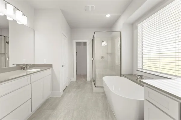 a spacious bathroom with a granite countertop sink a toilet mirror and a bathtub