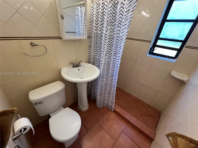 a bathroom with a toilet a sink and a mirror