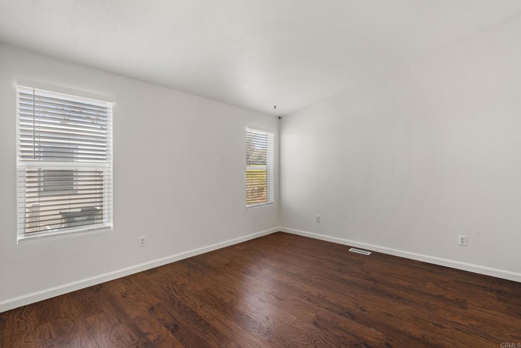 13125 Alpine Drive, Unit 212 Poway, CA 92064 - Photo 12 of 22 a view of an empty room with wooden floor and a window