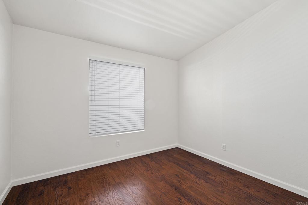 13125 Alpine Drive, Unit 212 Poway, CA 92064 - Photo 16 of 22 a view of an empty room with wooden floor and a window