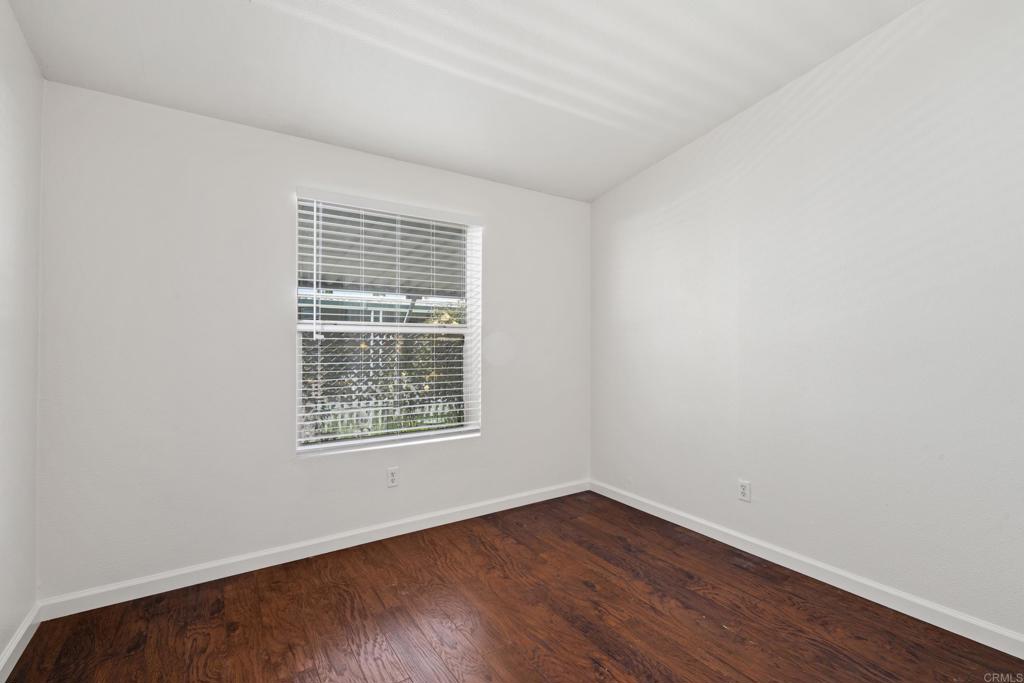13125 Alpine Drive, Unit 212 Poway, CA 92064 - Photo 17 of 22 a view of an empty room with wooden floor and a window