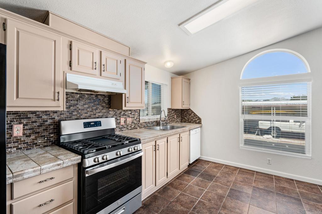 13125 Alpine Drive, Unit 212 Poway, CA 92064 - Photo 2 of 22 a kitchen with stainless steel appliances granite countertop a stove and a sink