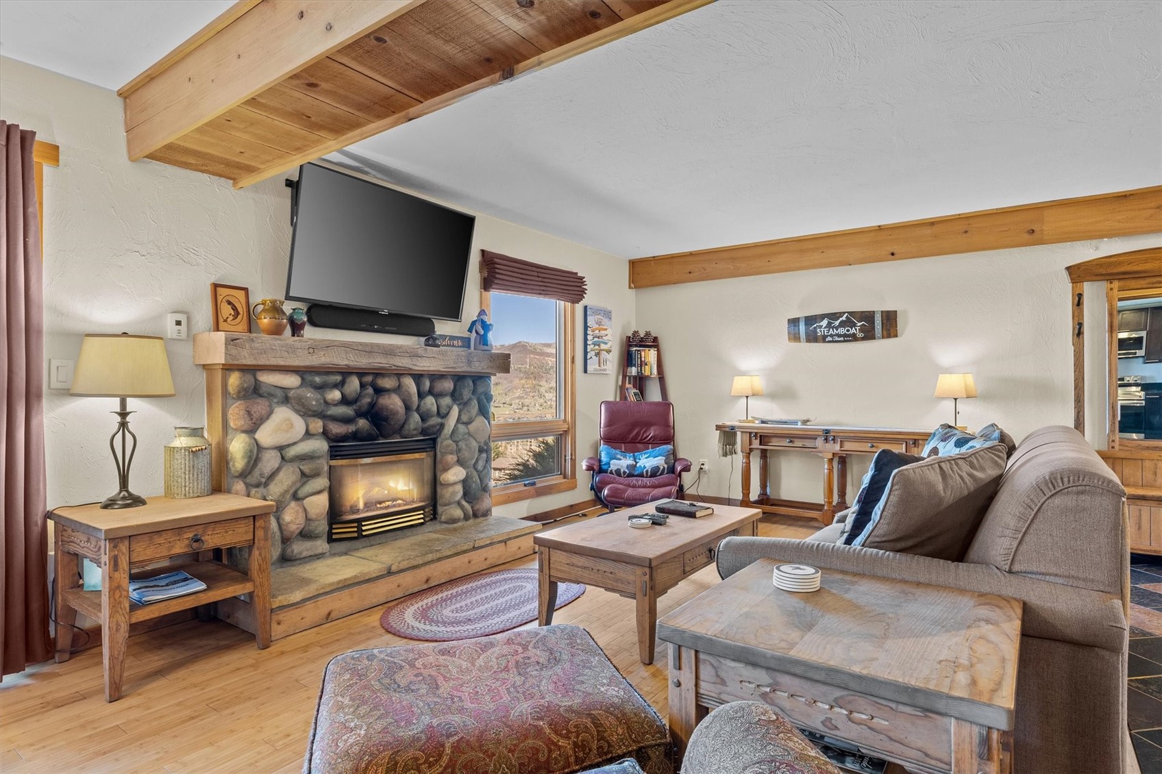 2602 Longthong Road, Unit 107 Steamboat Springs, CO 80487 - Photo 5 of 32 a living room with furniture a flat screen tv and a fireplace
