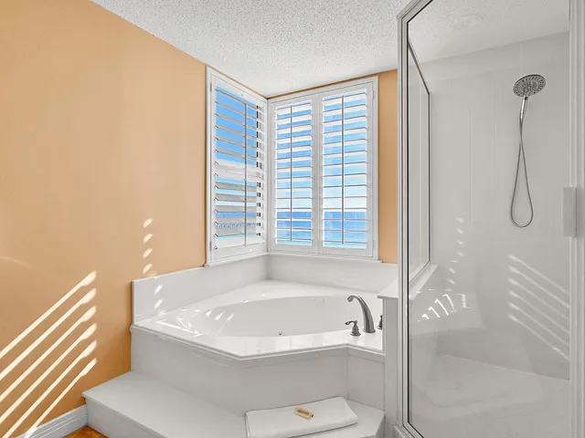 a bathroom with a granite countertop sink two mirror and a shower