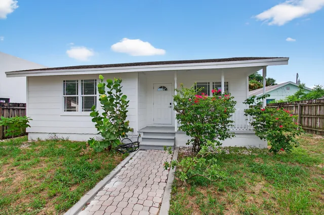 a front view of a house with garden and plants