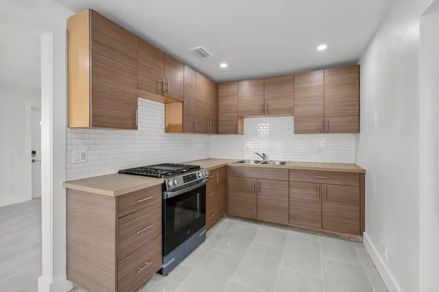 a kitchen with sink stove and cabinets
