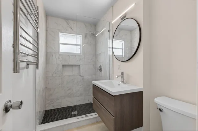 a bathroom with a sink a toilet and a mirror