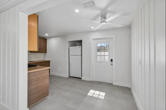 a view of a kitchen with a sink and dishwasher a stove top oven with wooden floor