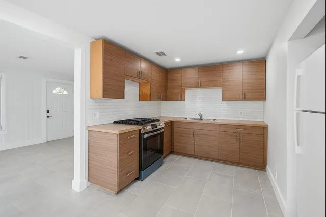 a kitchen with granite countertop white cabinets and stainless steel appliances