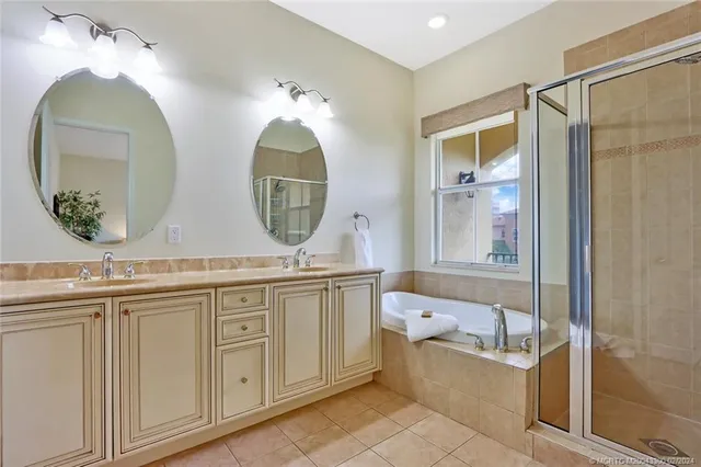 a bathroom with 2 sink tub and a mirror