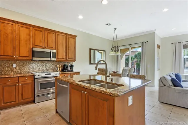 a kitchen with stainless steel appliances granite countertop a sink stove and microwave