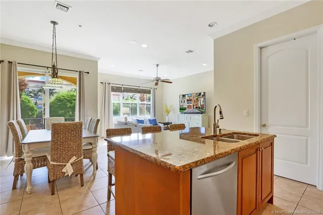 a kitchen that has a sink a table and chairs in it