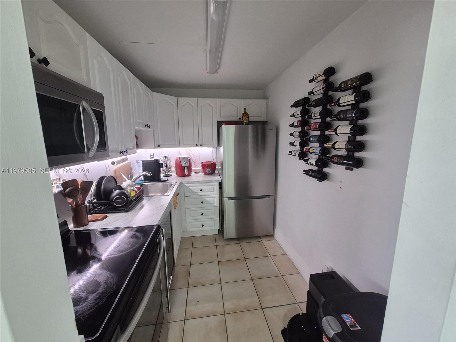 8405 Northwest 8th Street, Unit 304 Miami, FL 33126 - Photo 13 of 24 a kitchen with stainless steel appliances a refrigerator and a stove top oven