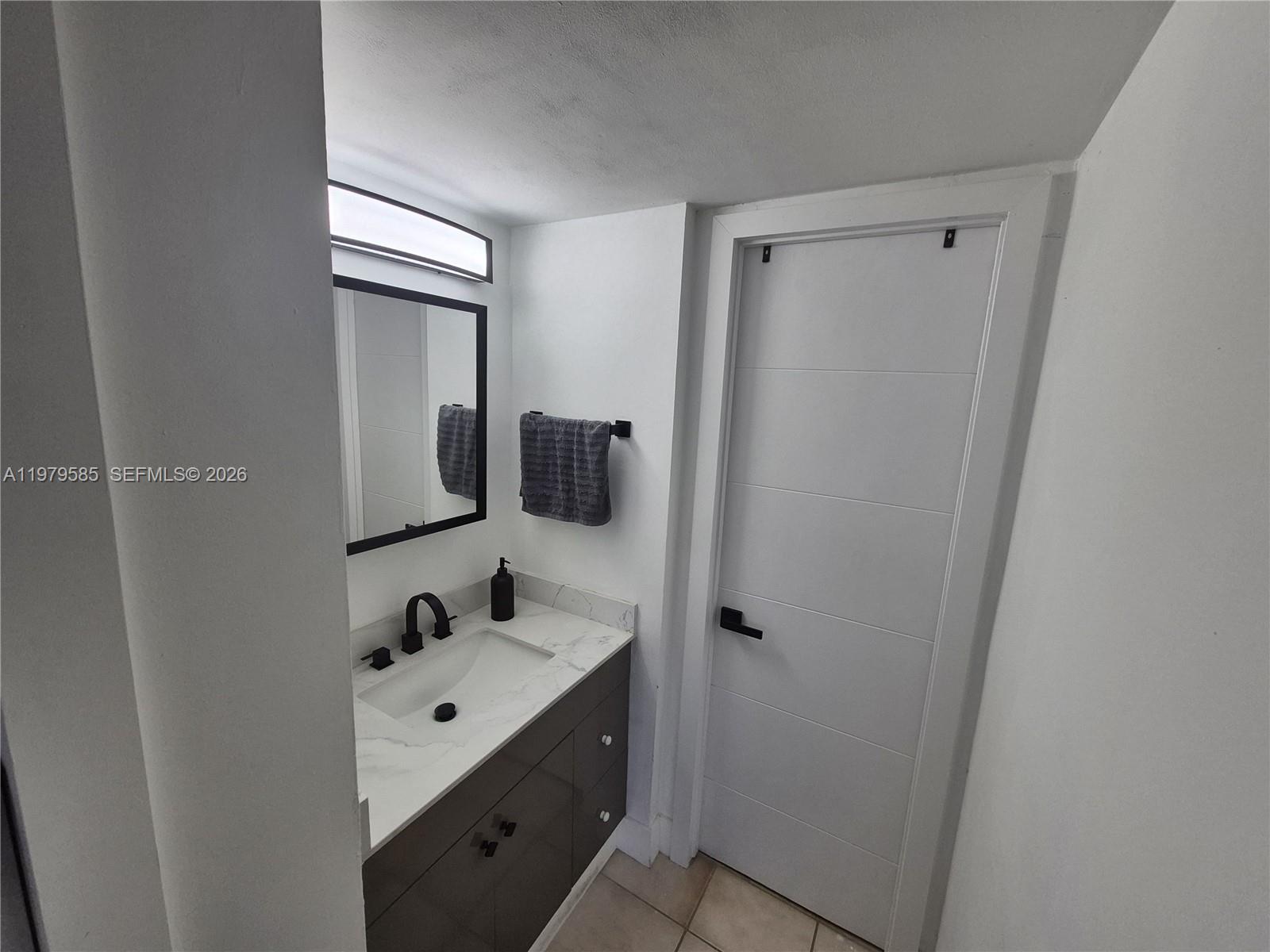 8405 Northwest 8th Street, Unit 304 Miami, FL 33126 - Photo 17 of 24 a bathroom with a sink and mirror