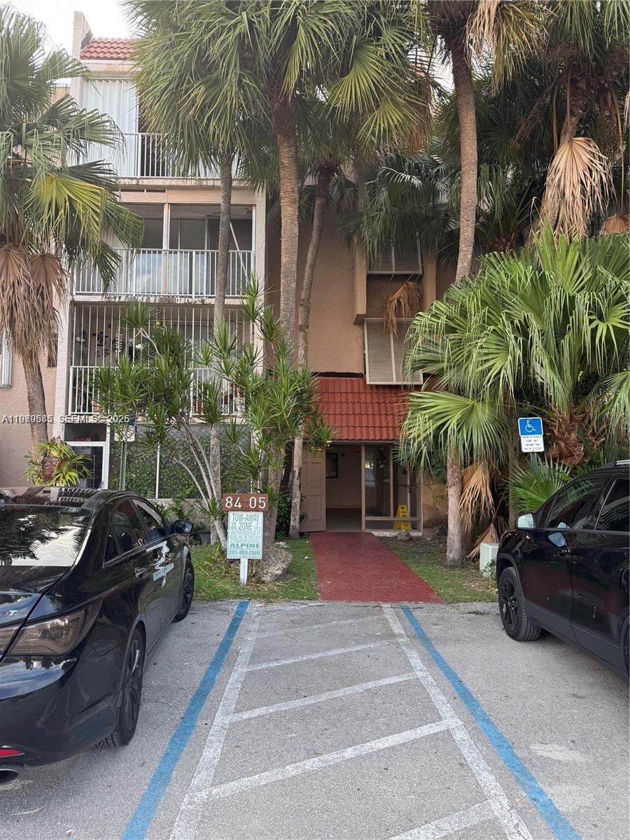 8405 Northwest 8th Street, Unit 304 Miami, FL 33126 - Photo 4 of 24 a view of a cars park in front of a building