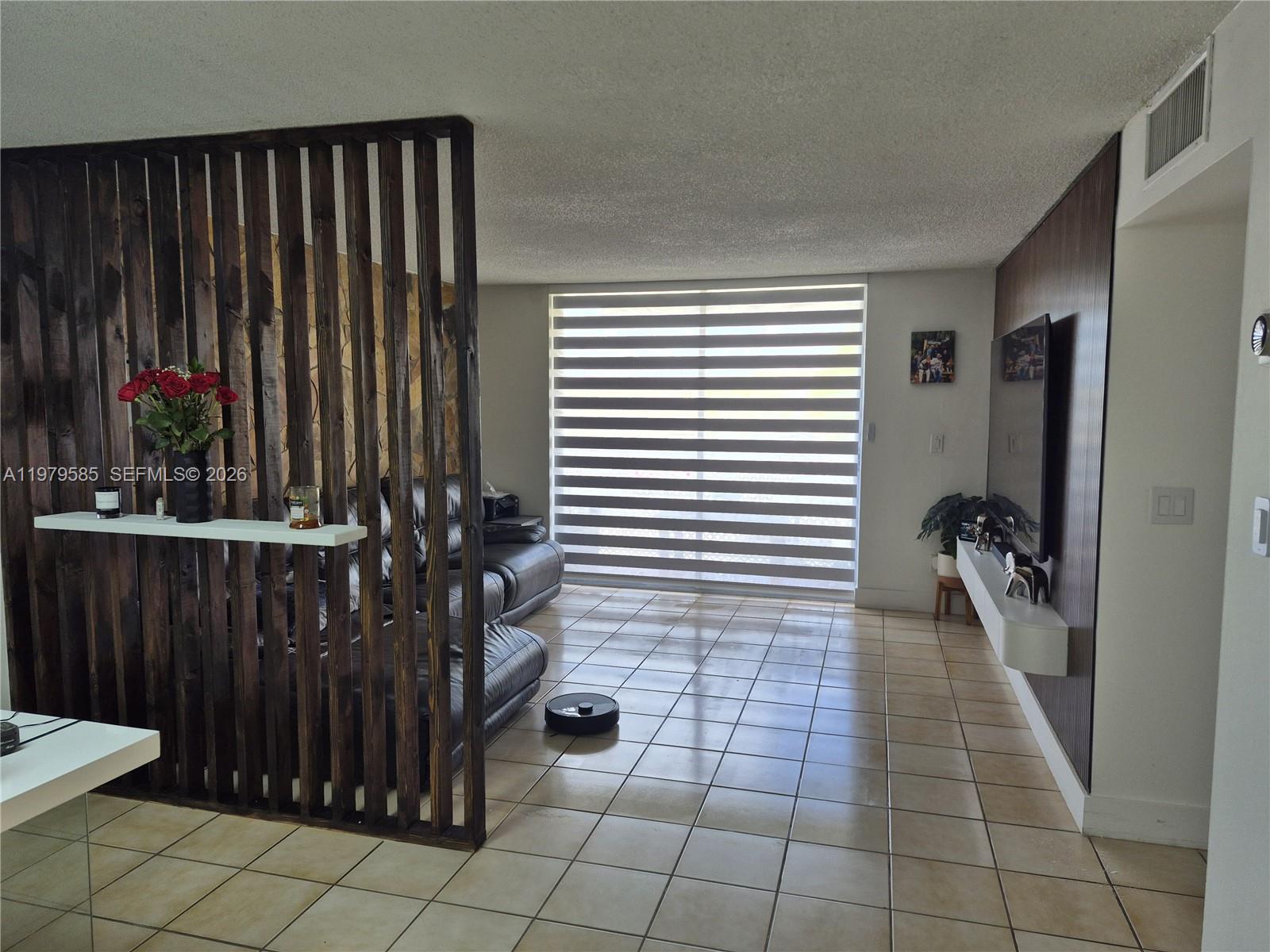 8405 Northwest 8th Street, Unit 304 Miami, FL 33126 - Photo 8 of 24 a hallway with a black white checkered floor and a living room