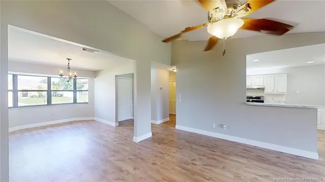 a view of an empty room with window and wooden floor