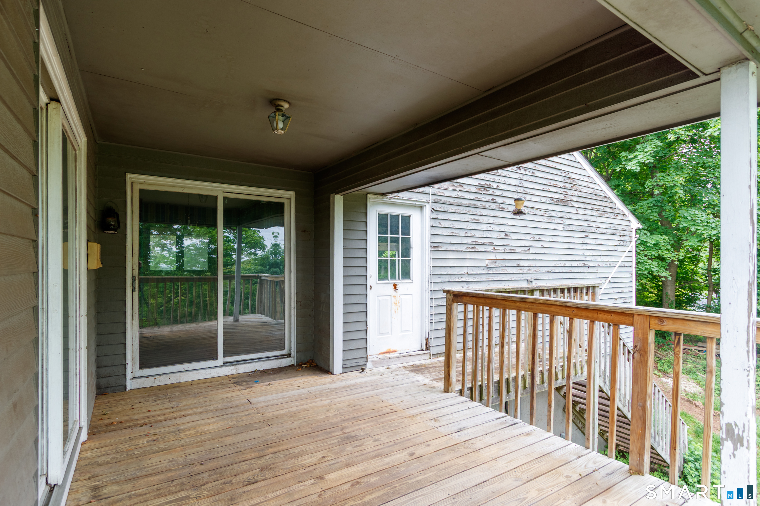 63 High Hill Road Wallingford, CT 06492 - Photo 5 of 34 a porch with wooden floor in front of a house
