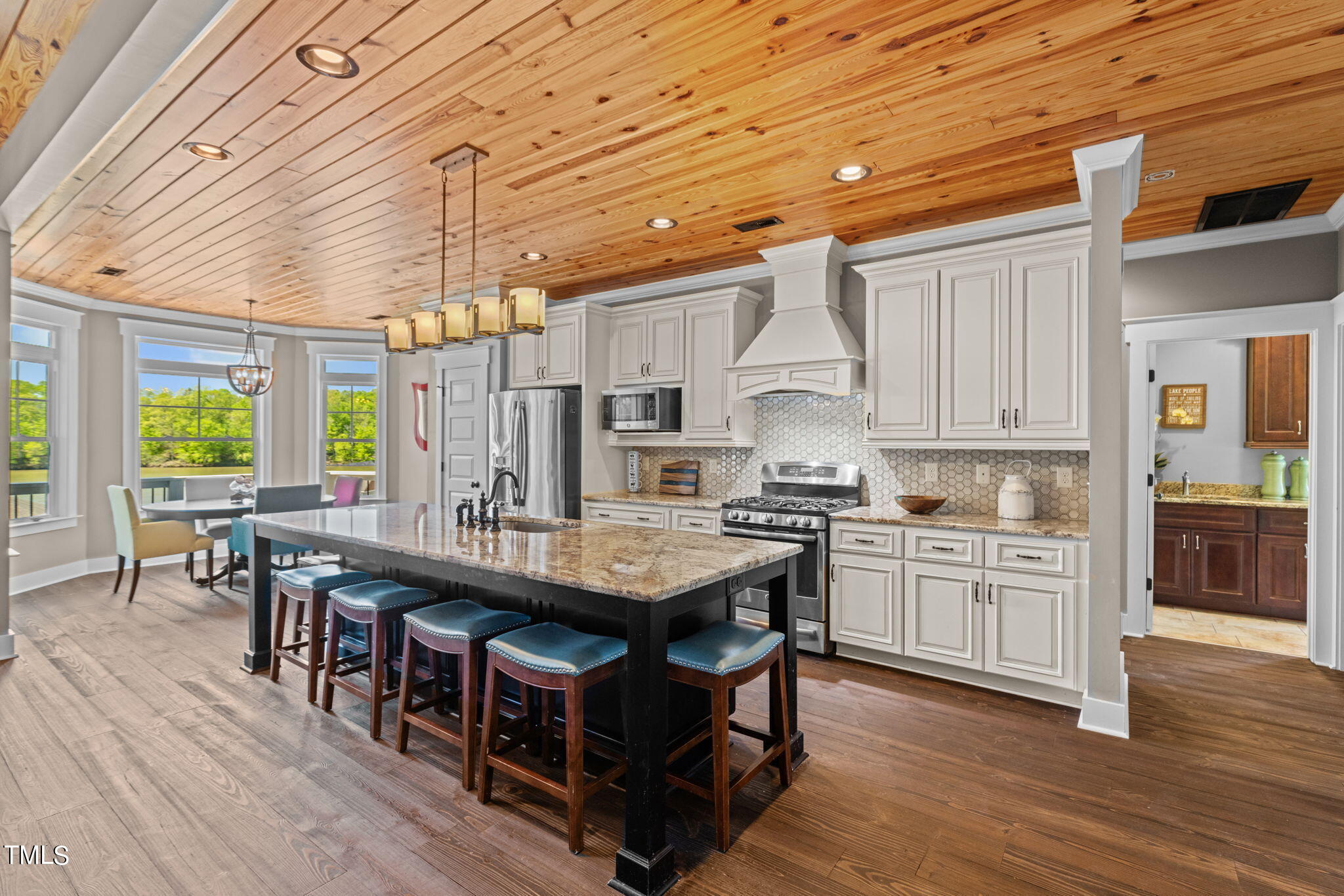 186 Polaris Point Semora, NC 27343 - Photo 15 of 73 a large kitchen with kitchen island a stove a sink a dining table and chairs