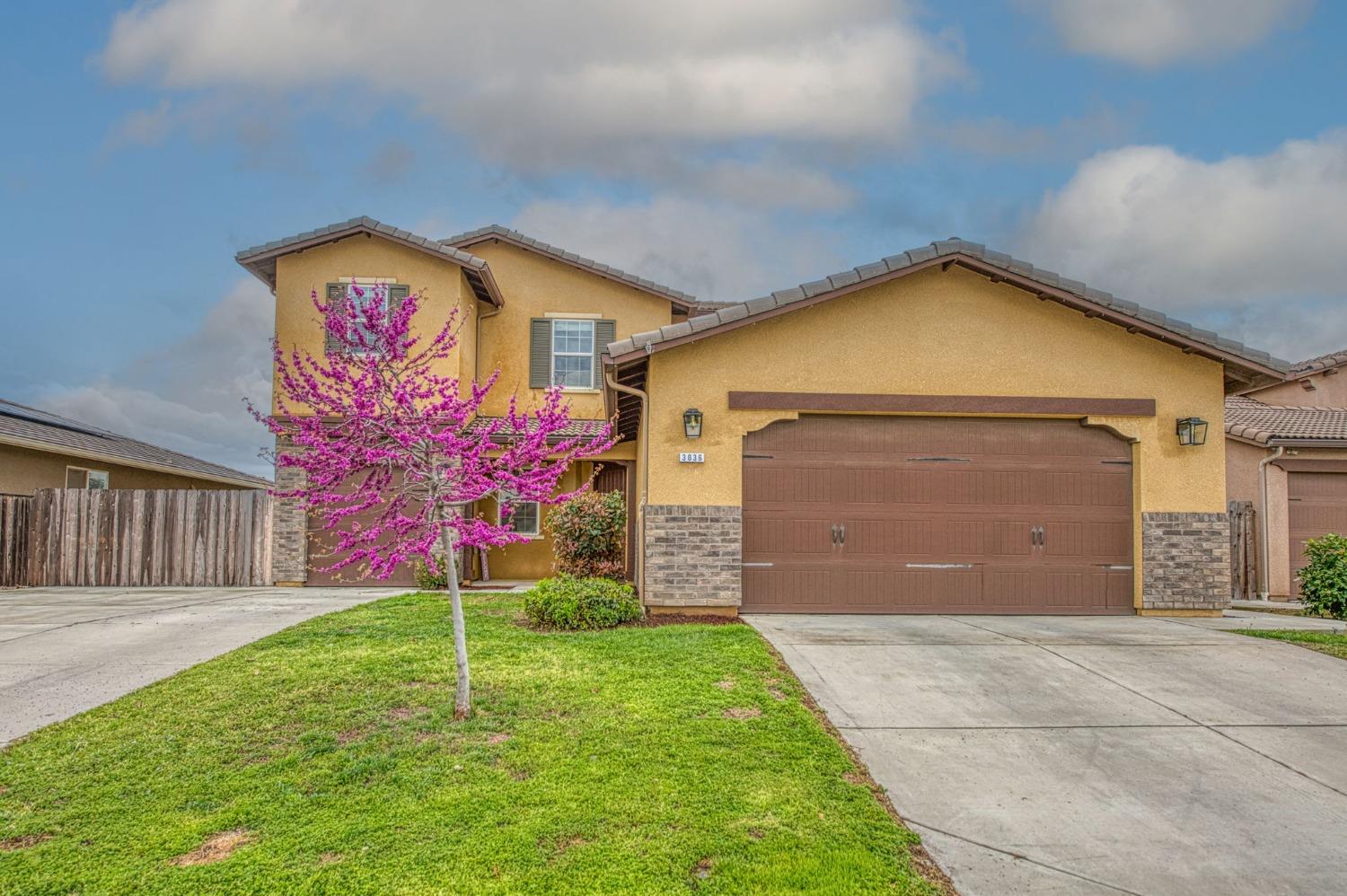 3036 Portals Avenue Clovis, CA 93619 - Photo 1 of 53 a front view of a house with a yard and garage