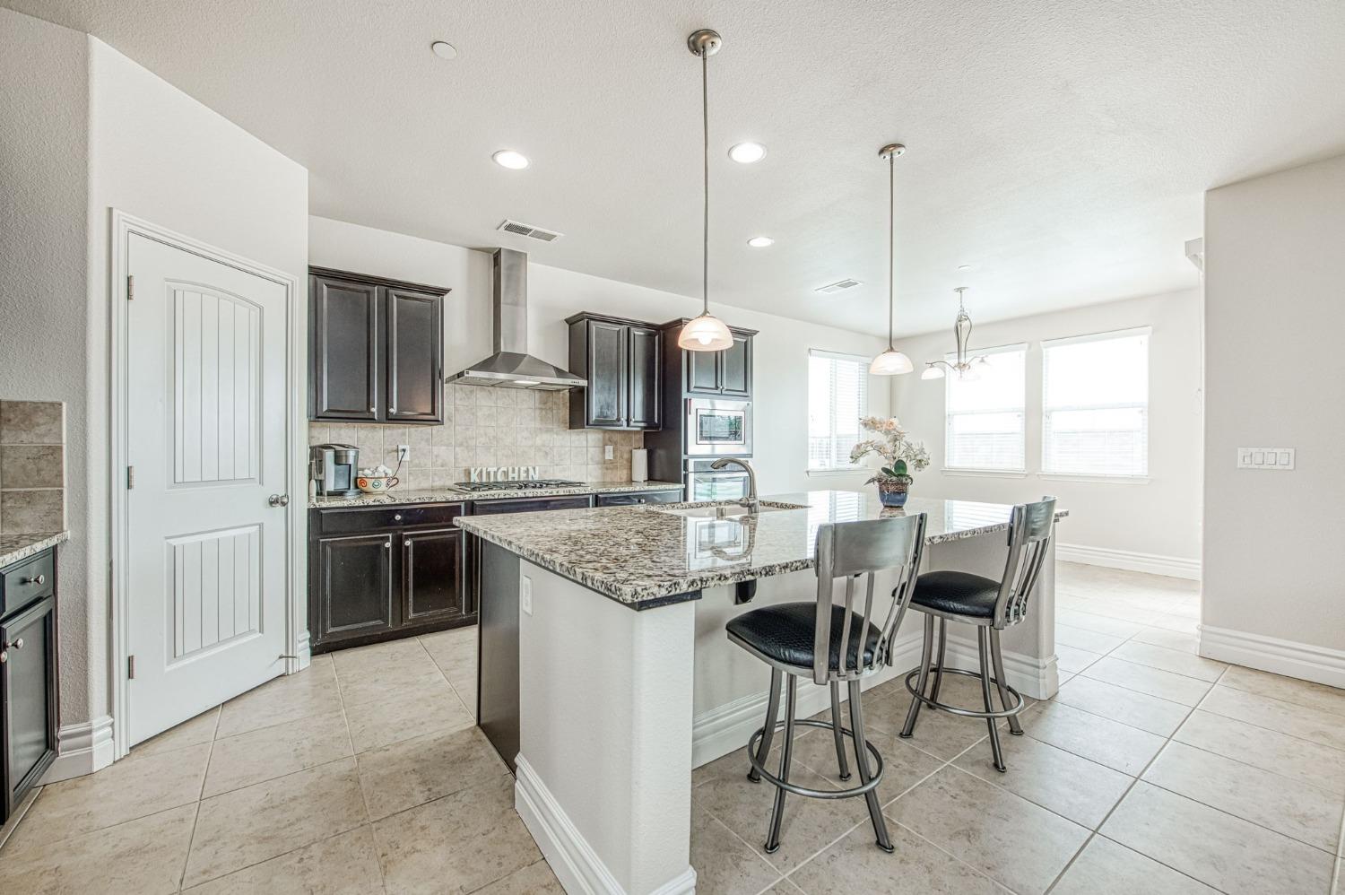 3036 Portals Avenue Clovis, CA 93619 - Photo 19 of 53 a kitchen with stainless steel appliances granite countertop a stove top oven a sink refrigerator and cabinets