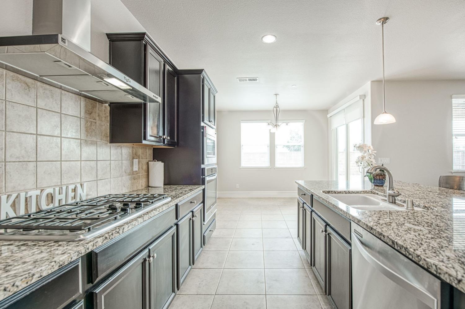 3036 Portals Avenue Clovis, CA 93619 - Photo 23 of 53 a kitchen with stainless steel appliances granite countertop a stove and a sink