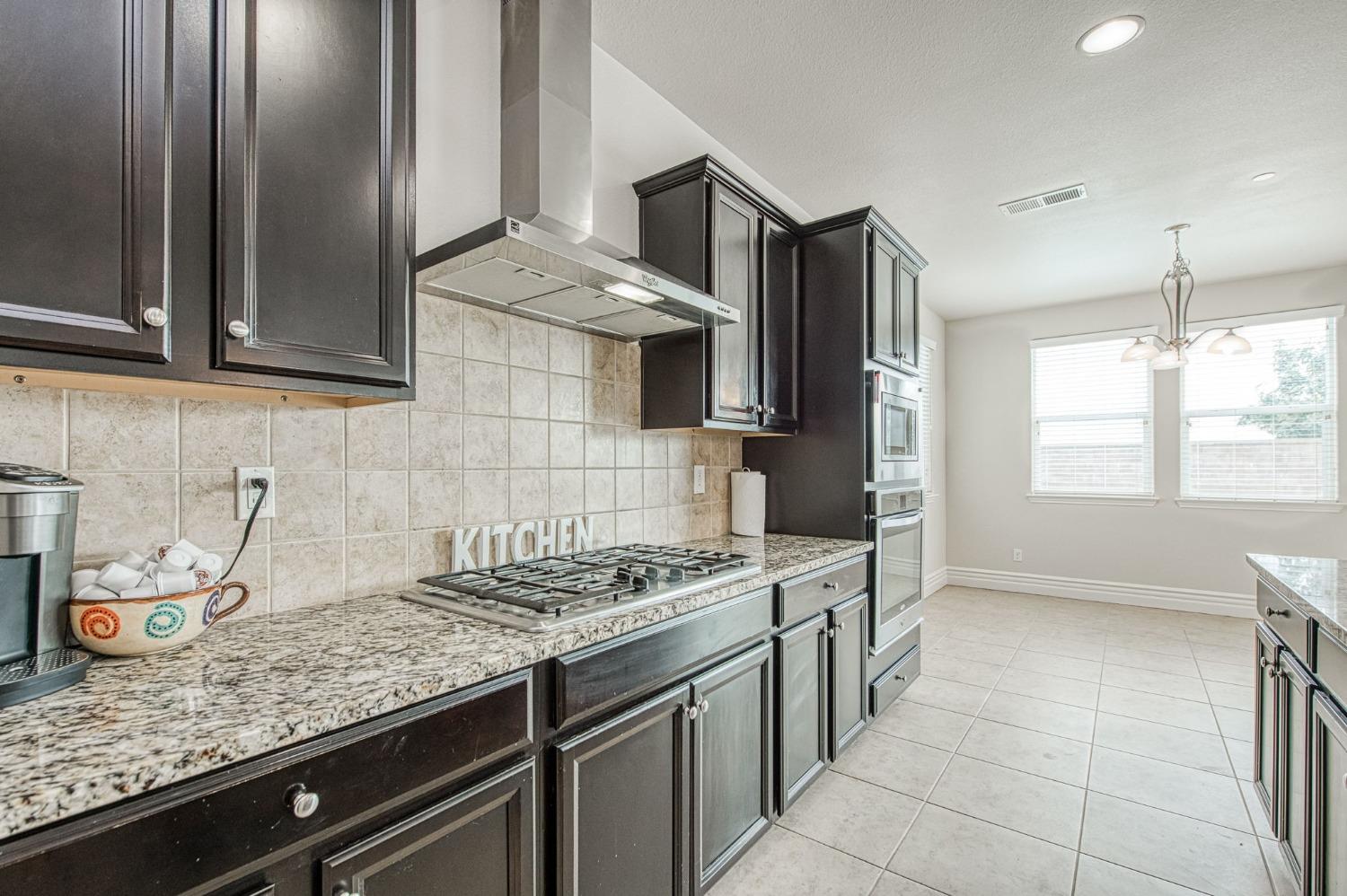 3036 Portals Avenue Clovis, CA 93619 - Photo 24 of 53 a kitchen with stainless steel appliances granite countertop a sink stove and cabinets
