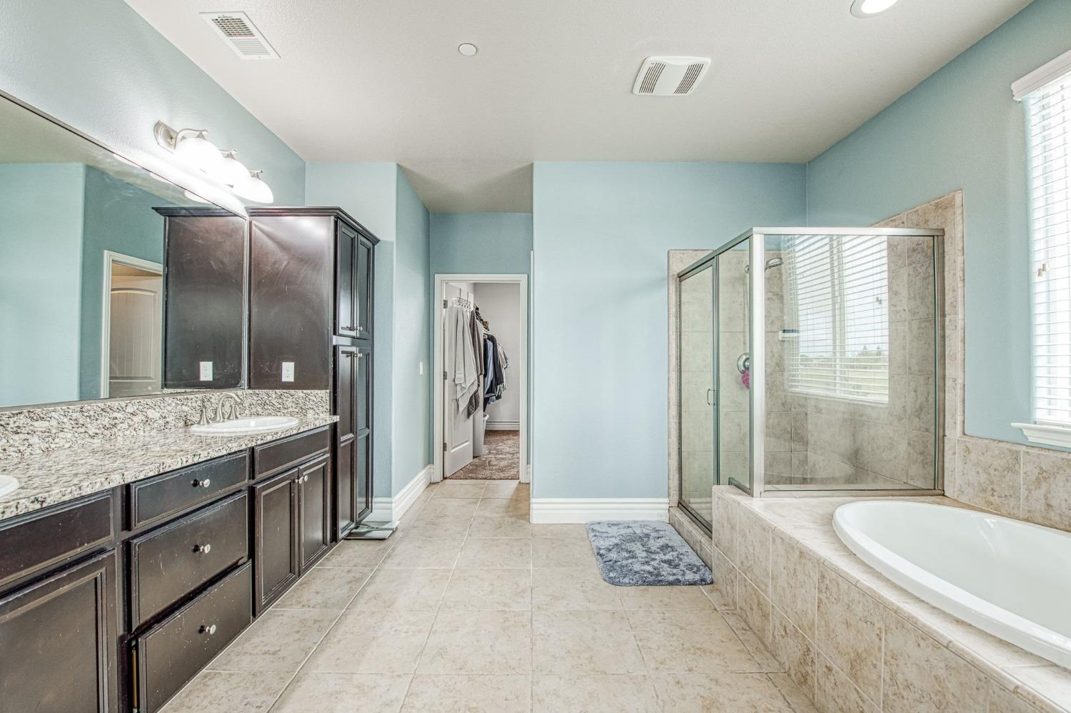 3036 Portals Avenue Clovis, CA 93619 - Photo 38 of 53 a spacious bathroom with a granite countertop tub sink and mirror