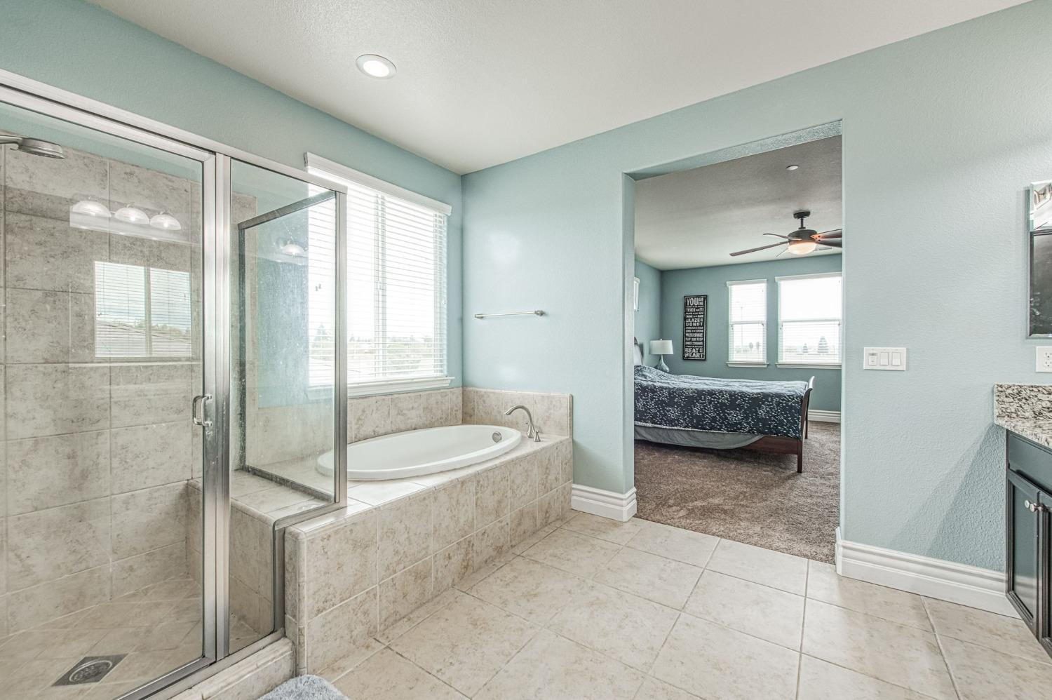 3036 Portals Avenue Clovis, CA 93619 - Photo 41 of 53 a en suite bathroom with a tub sink and mirror