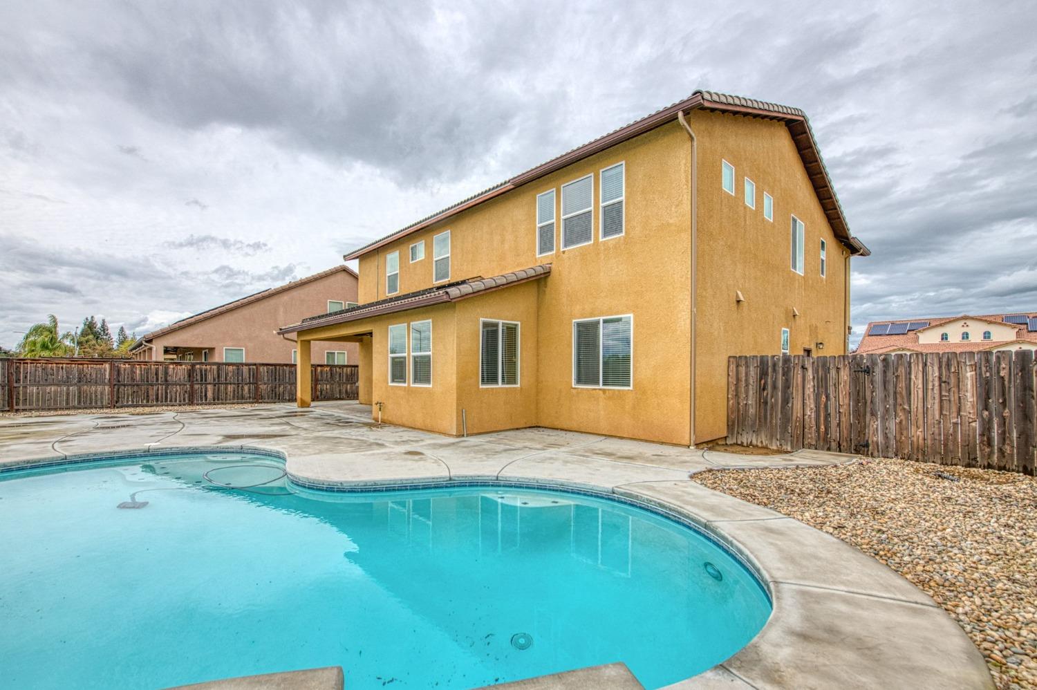 3036 Portals Avenue Clovis, CA 93619 - Photo 48 of 53 a front view of a house with a swimming pool