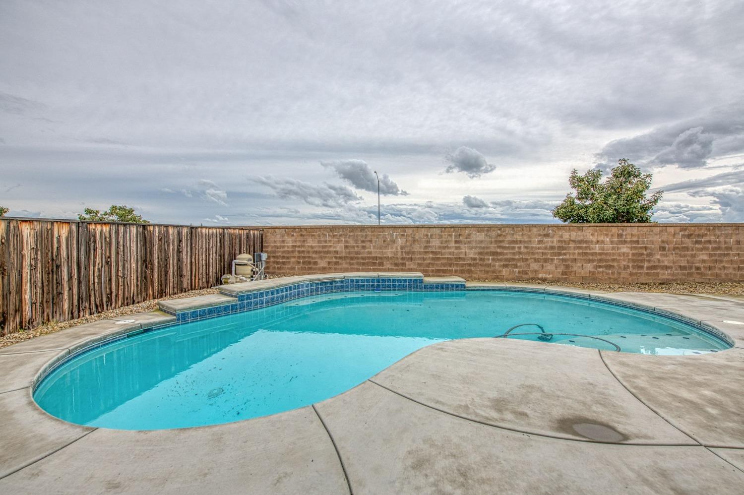3036 Portals Avenue Clovis, CA 93619 - Photo 51 of 53 a view of swimming pool with seating space and wooden fence