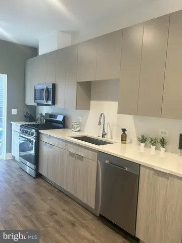 a kitchen with a sink a stove and cabinets