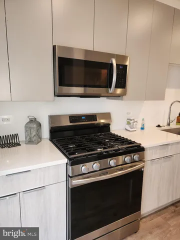 a kitchen with microwave cabinets and stove top oven