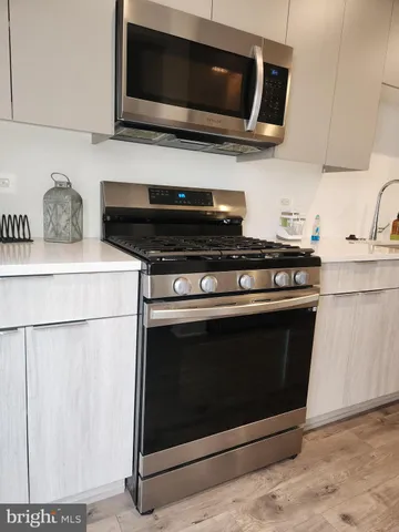 a kitchen with stainless steel appliances a stove a microwave and cabinets