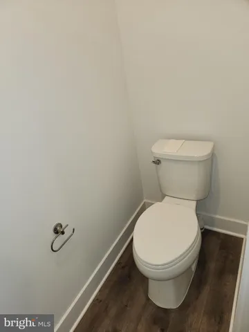 a white toilet sitting next to a white wall