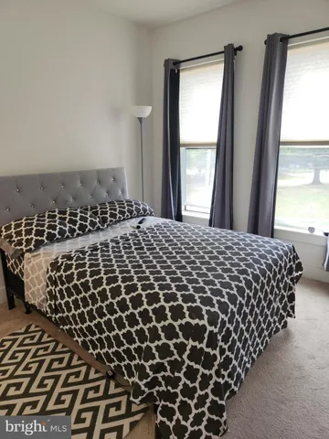 a large bed sitting in a bedroom next to a window
