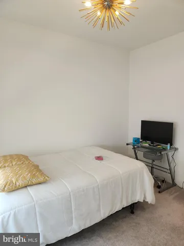 a view of a hallway with wooden floor and cabinet