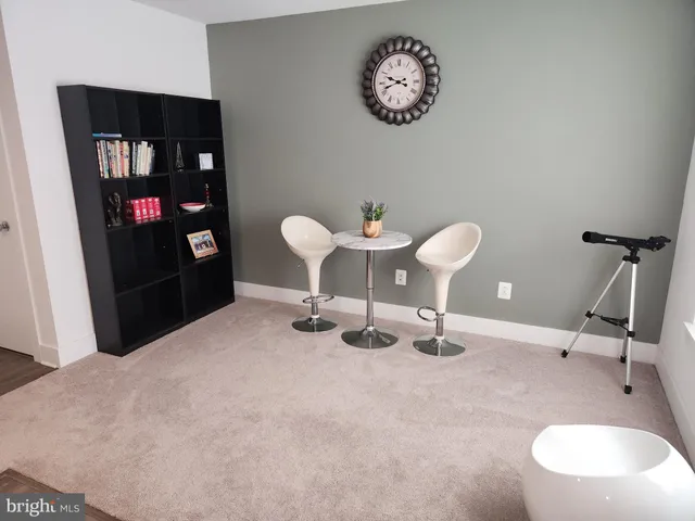 a room with a table chairs and a painting