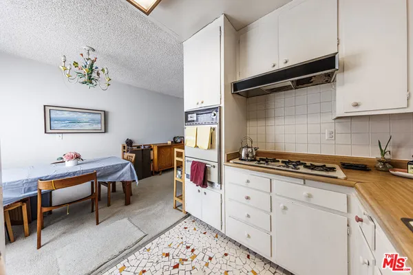 a kitchen with furniture wooden floor and stainless steel appliances