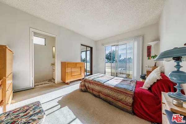 a bedroom with bed and glass door
