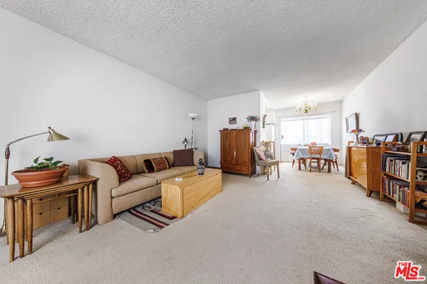 a living room with furniture and a table and a bookshelf