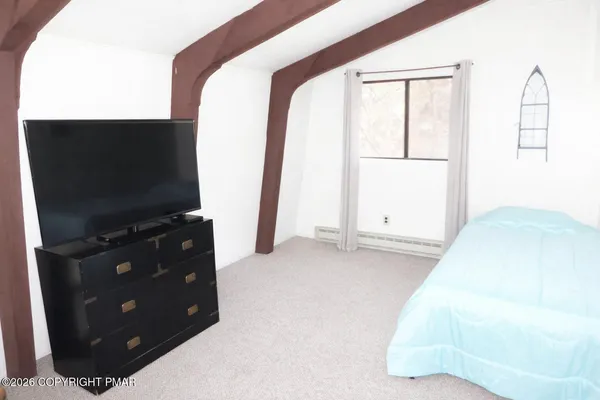 a bedroom with a bed and a flat screen tv