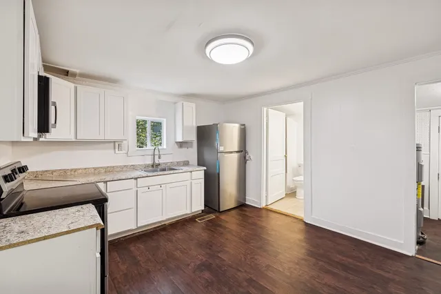 a kitchen with stainless steel appliances granite countertop a refrigerator sink and stove