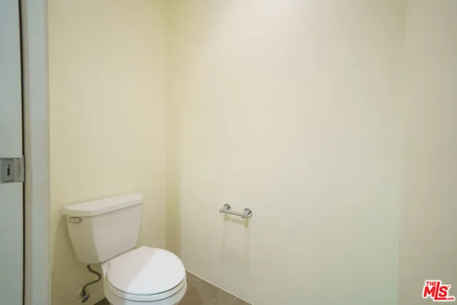 a white toilet sitting next to a white wall