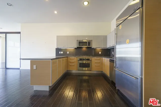 a kitchen with granite countertop stainless steel appliances a counter top space and cabinets